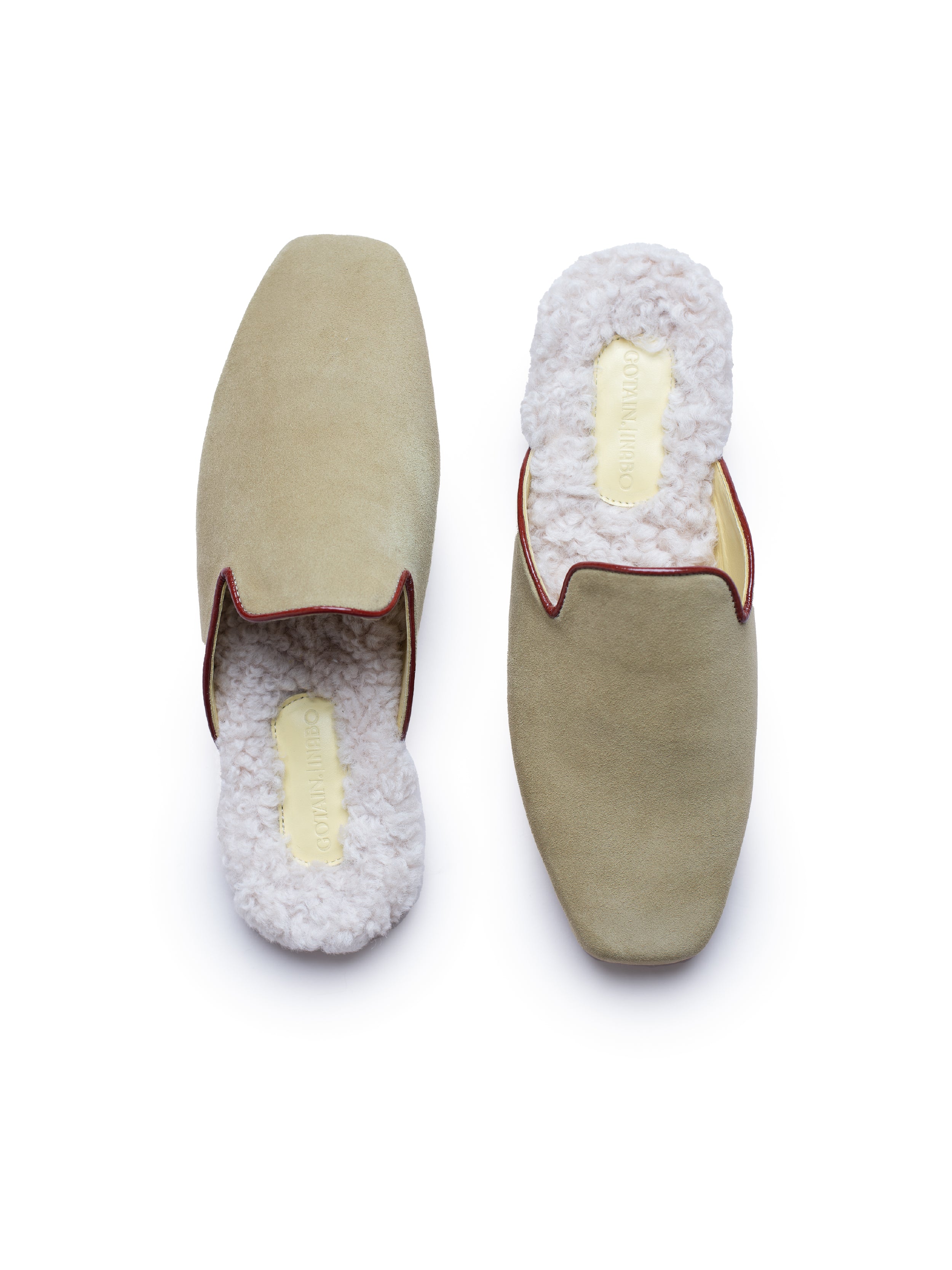 Pair of olive green suede slippers with white fur lining on a white background