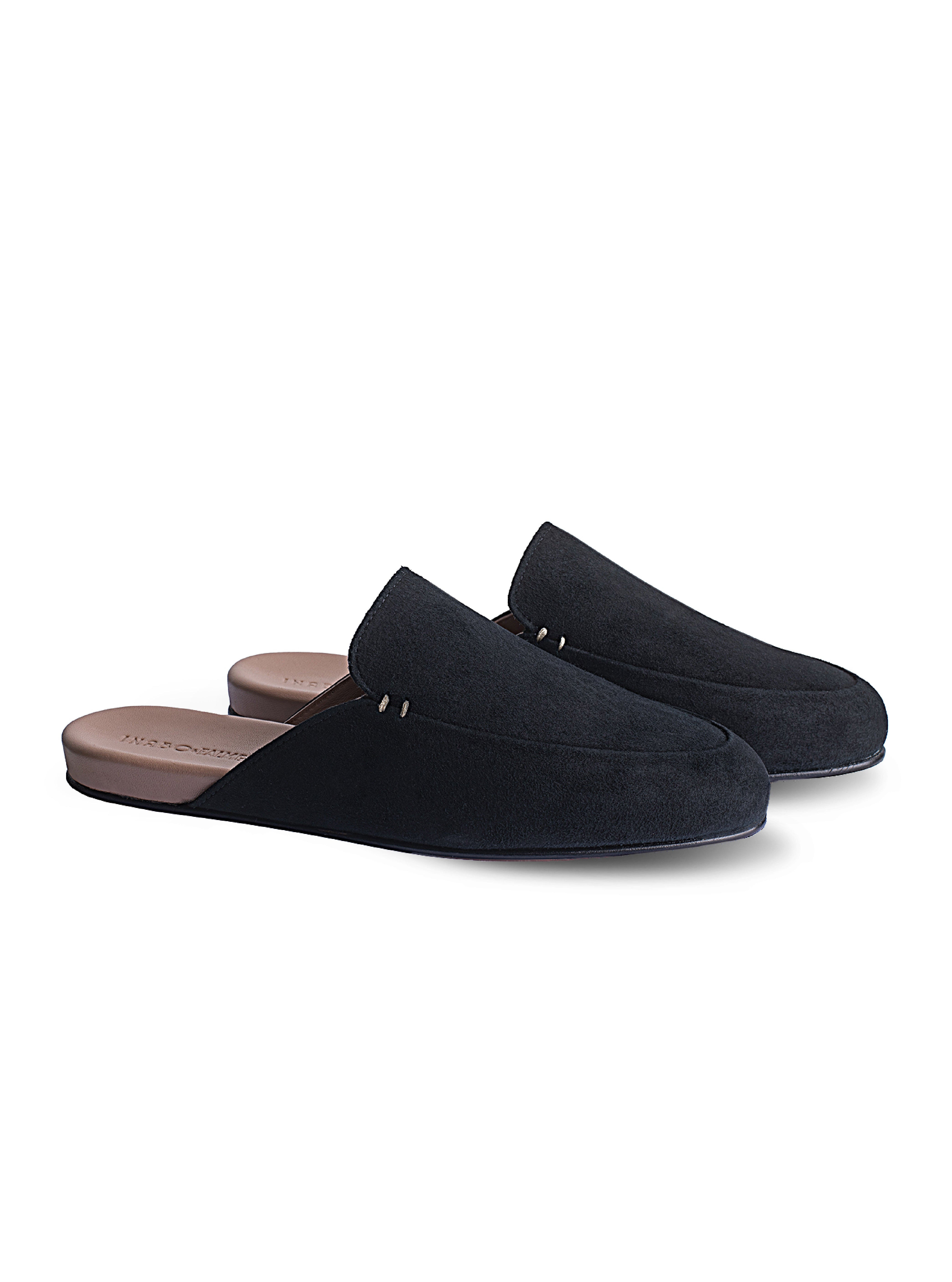 Women's pair of black suede loafers on a white background.