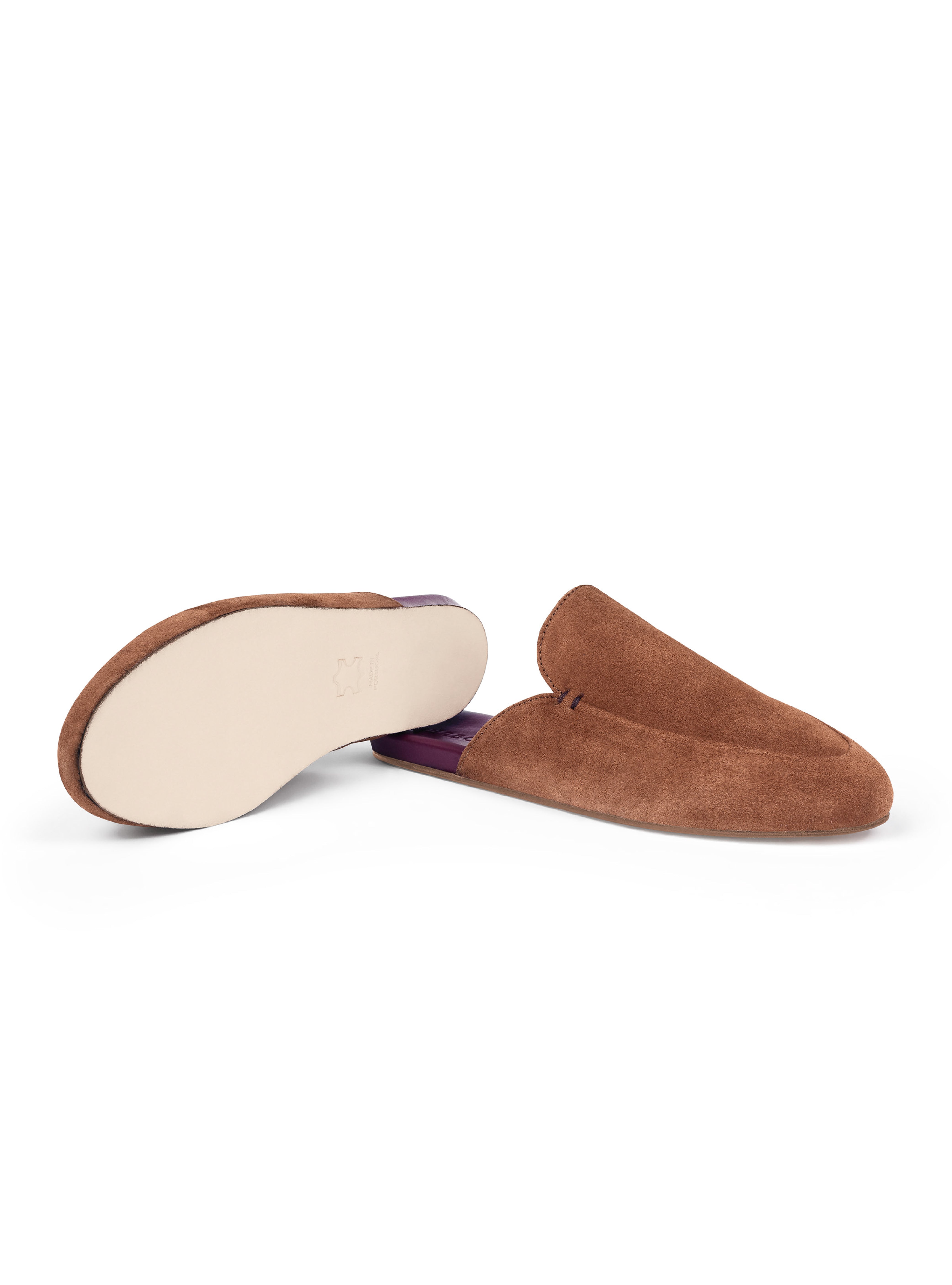 Women's pair of brown suede slippers with a burgundy insole and leather outsole on a white background.