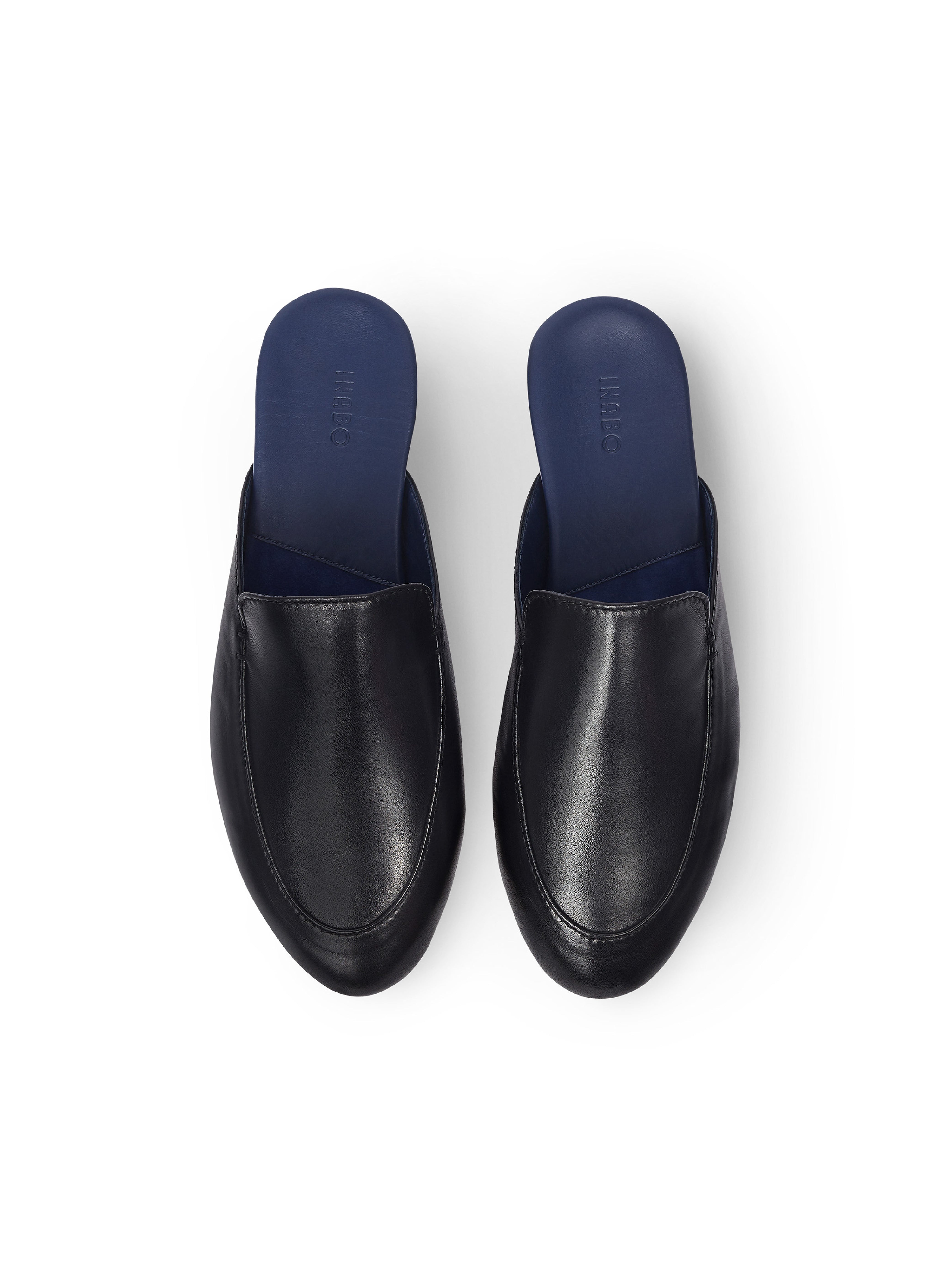 Men's pair of black leather slippers with  blue interior on a white background