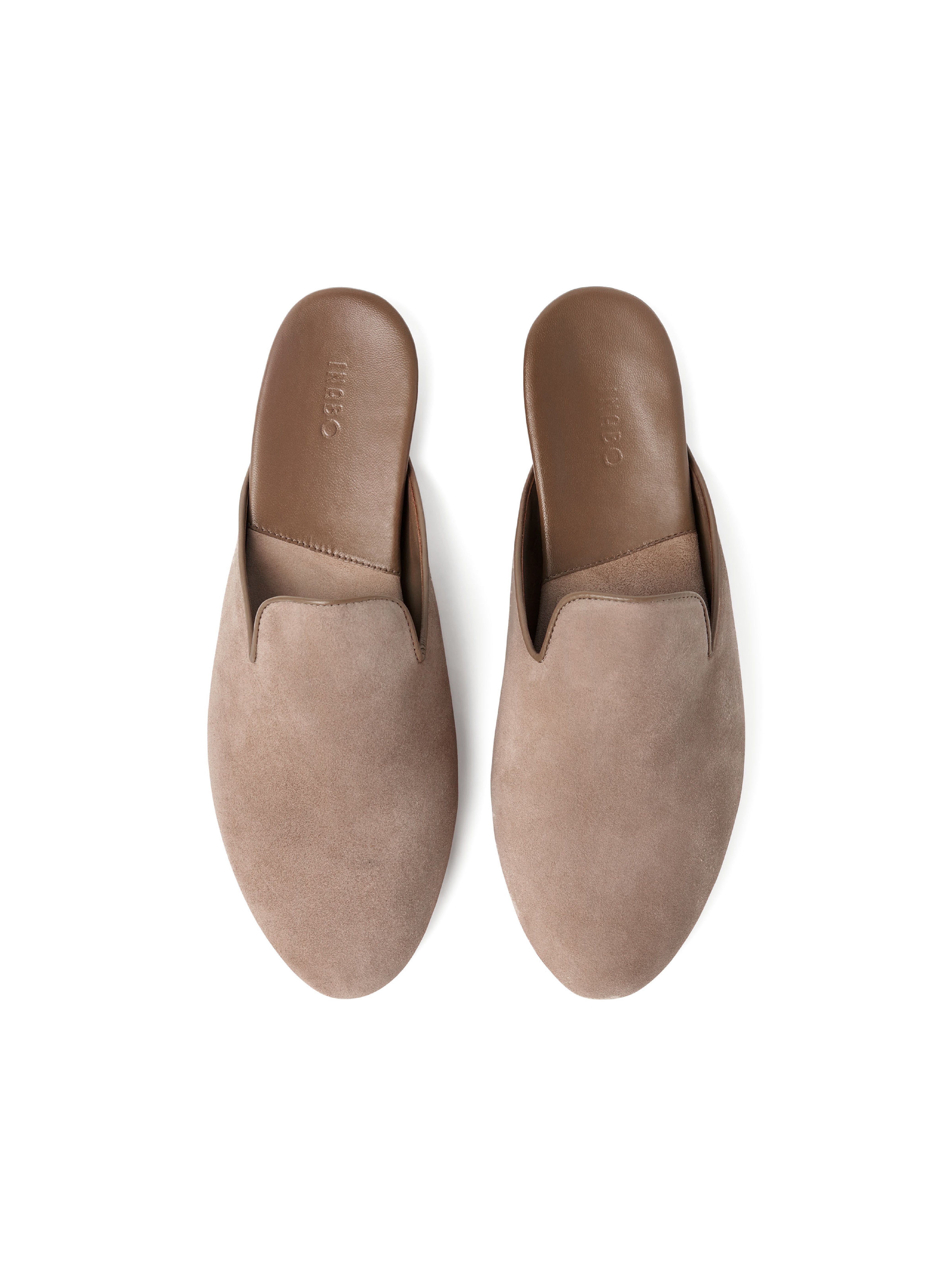 Pair of taupe suede slippers on a white background