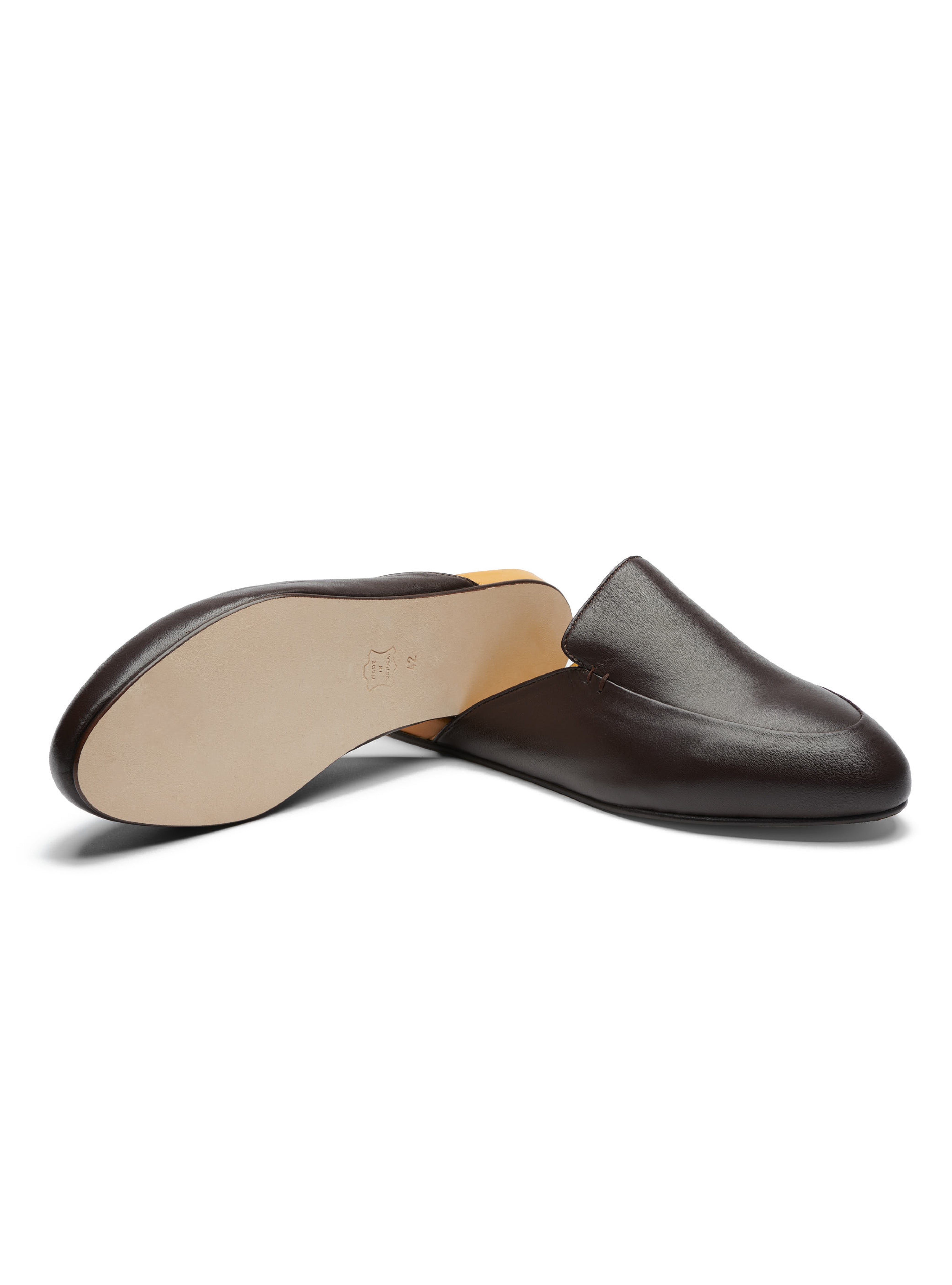 Men's pair of dark brown leather loafers with leather outsole on a white background