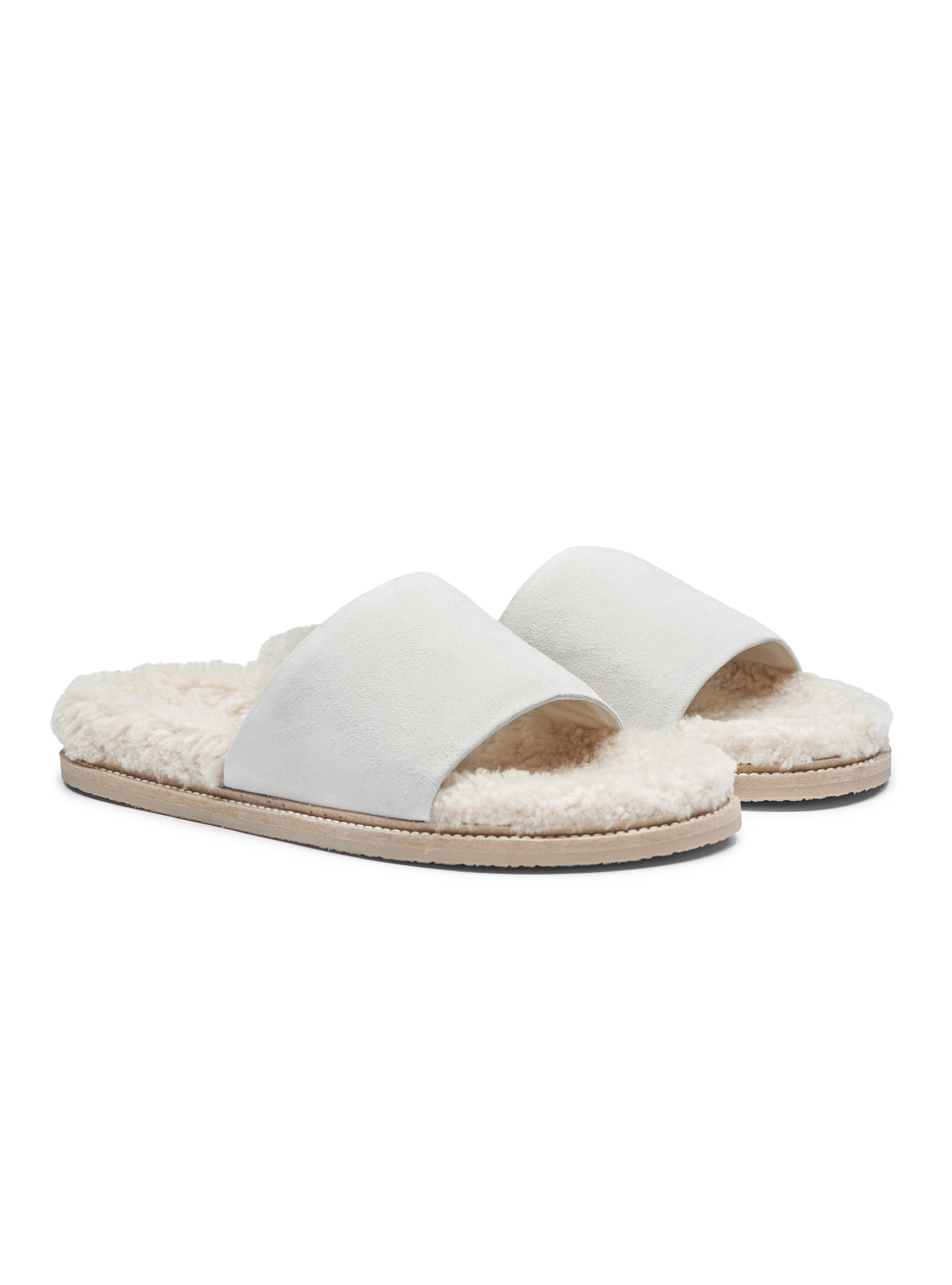 Women's pair of white slippers with shearling lining on a white background