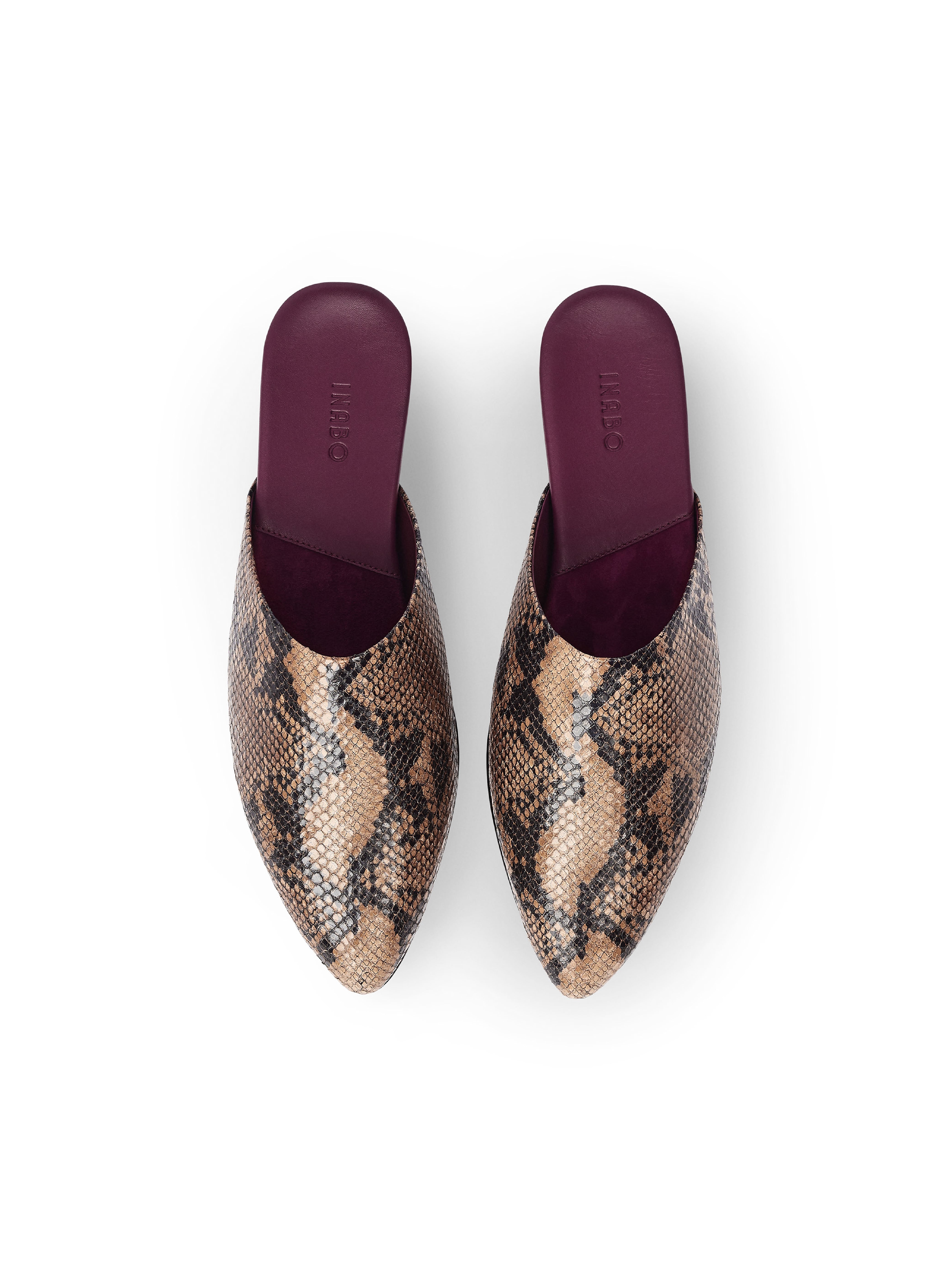 Women's pair of snake print mules with burgundy insole on a white background