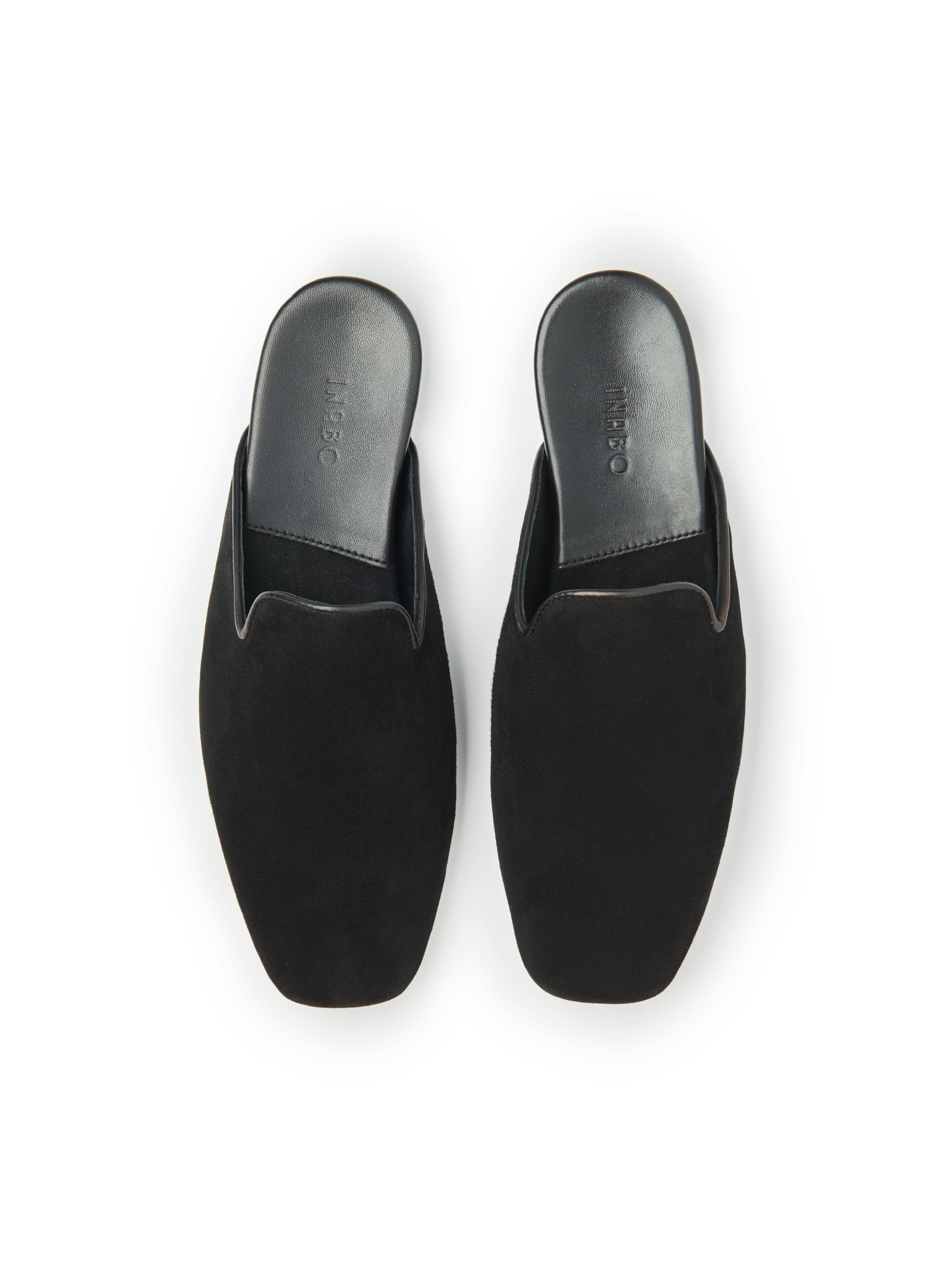Women's pair of black suede slippers on a white background