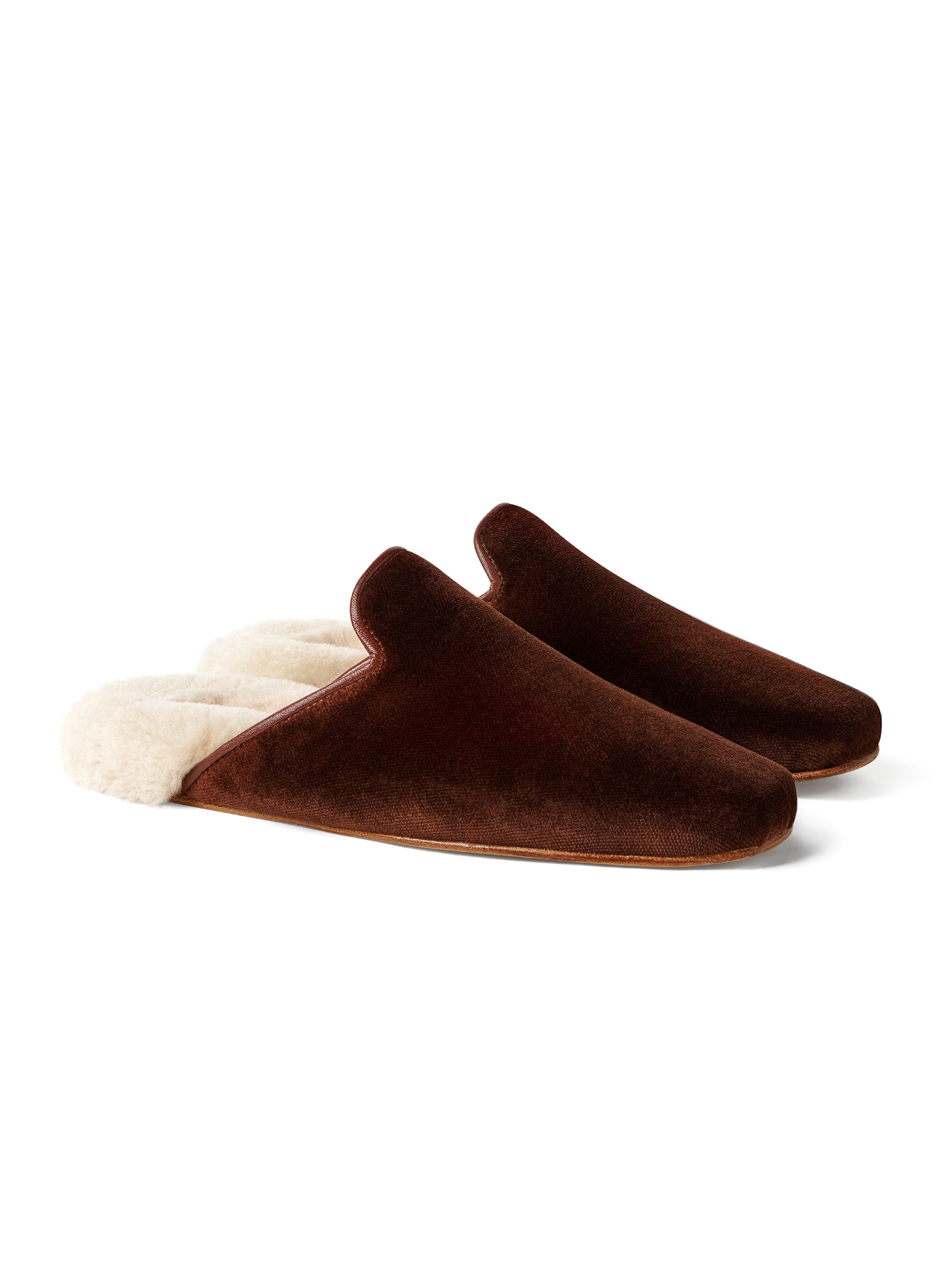 Women's pair of brown velvet slippers with white fur on a white background