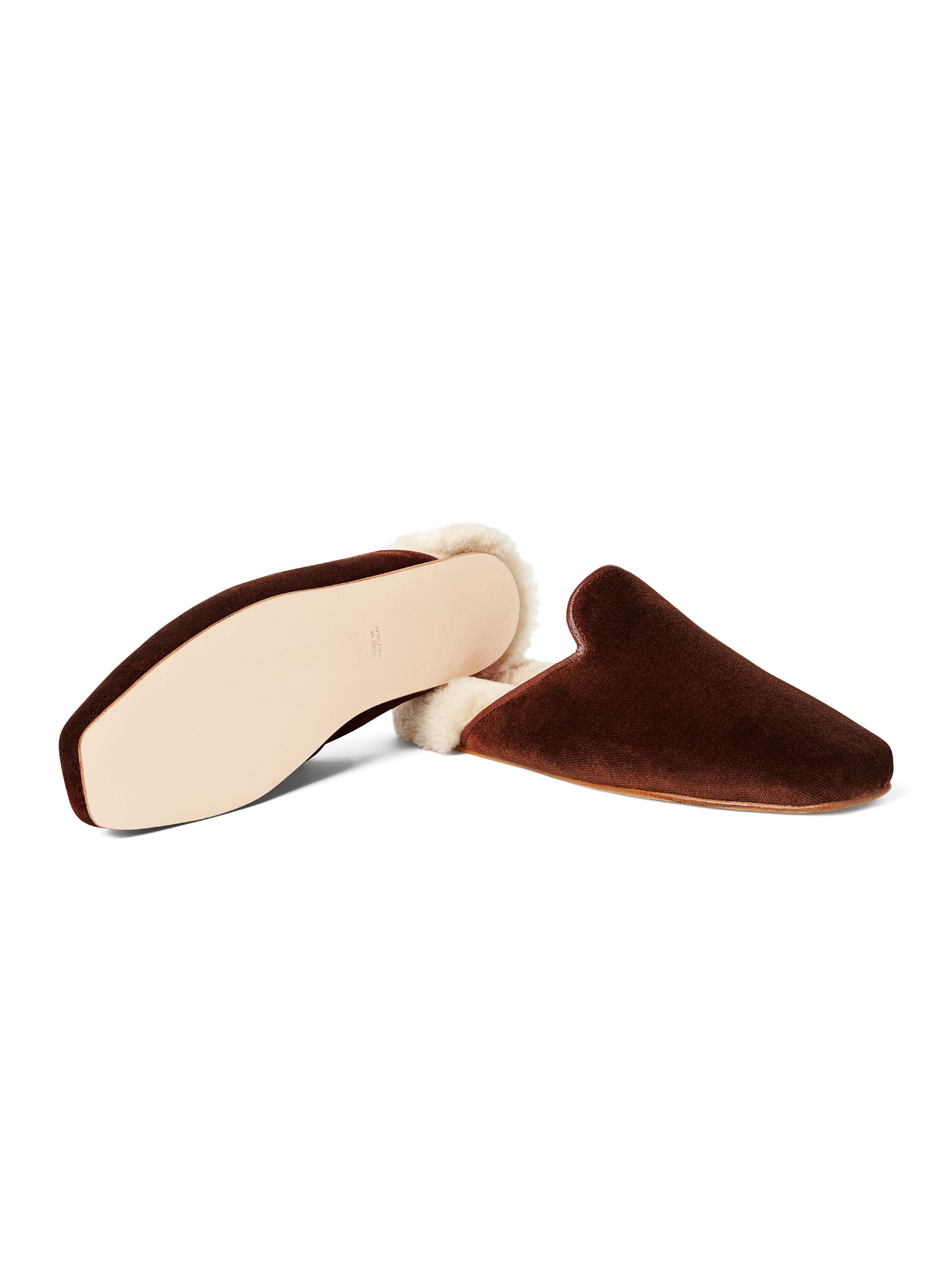Women's pair of brown velvet slippers with white fur and leather outsole on a white background