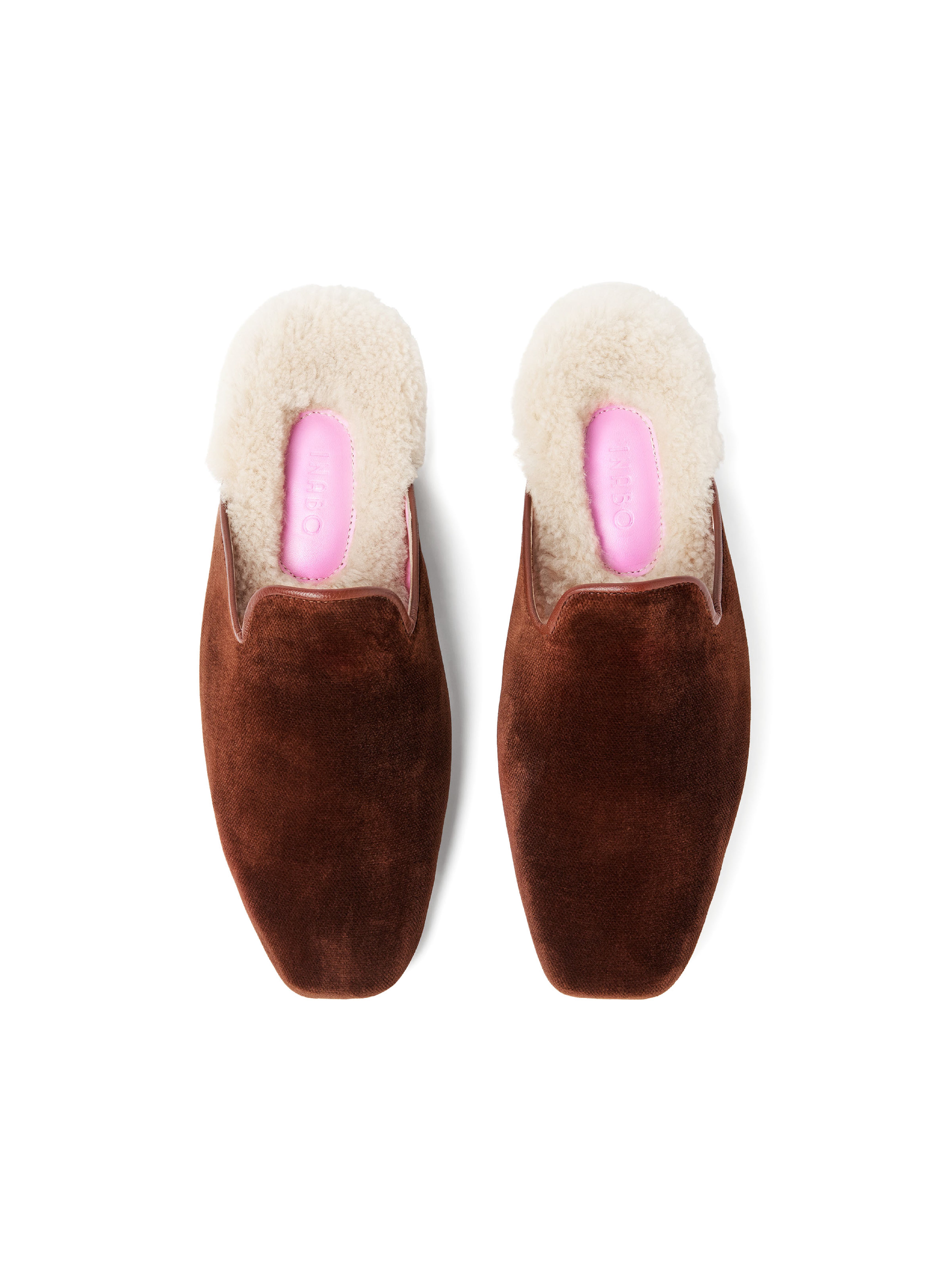 Women's pair of brown velvet slippers with white fur and pink interior on a white background