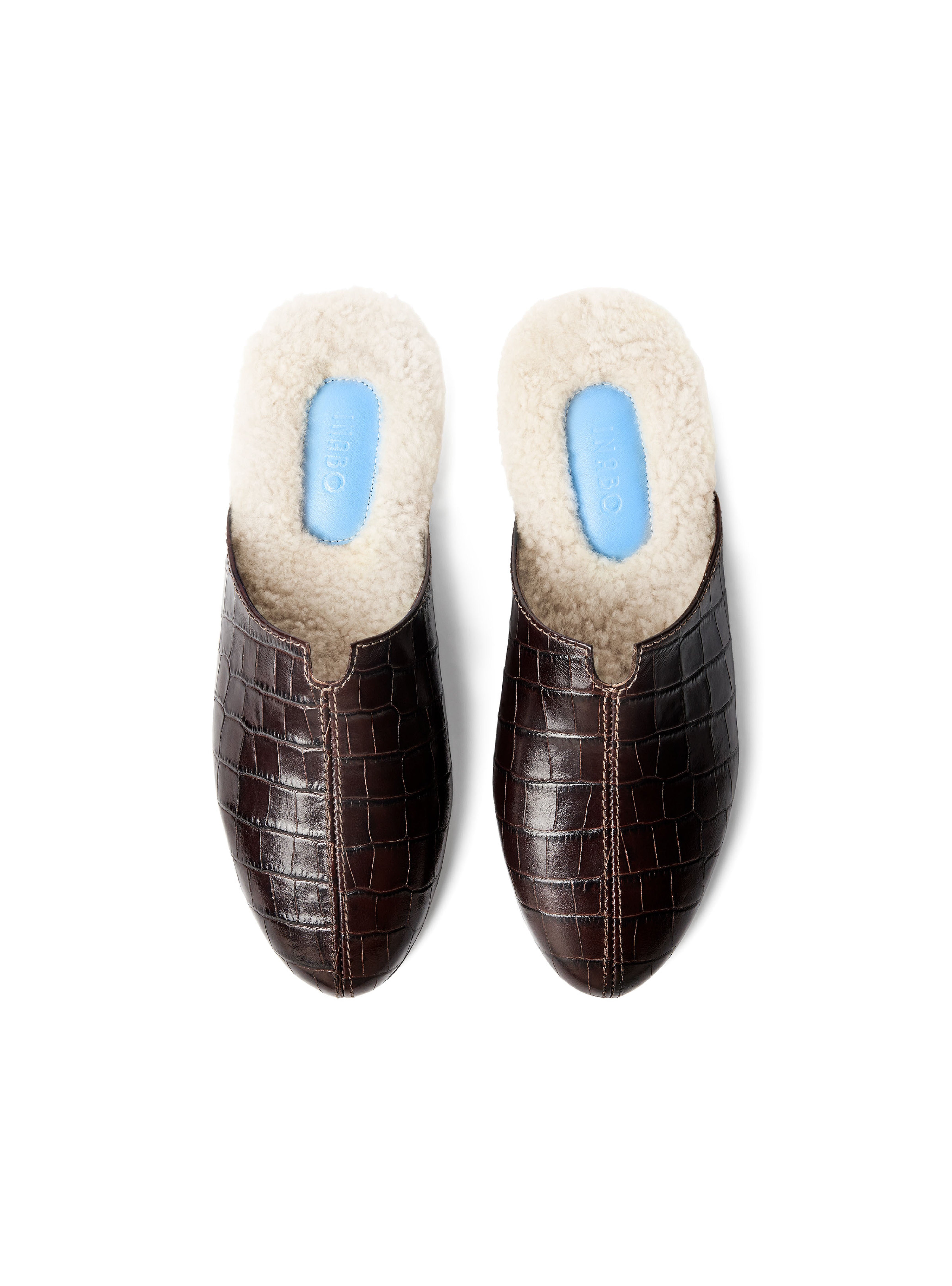 Women's pair of croc-embossed dark brown leather with fur lining on a white background.