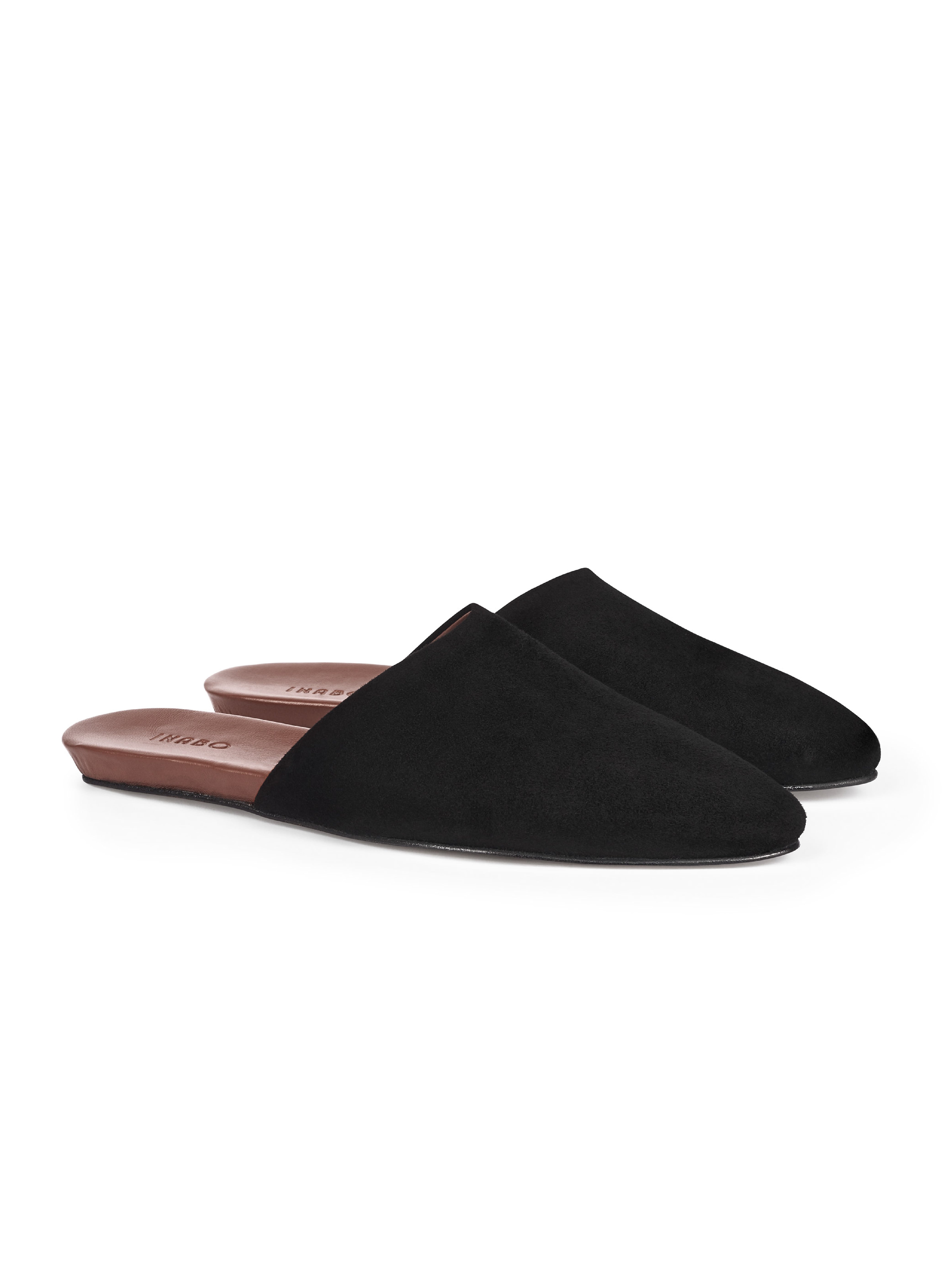 Women's pair of black suede pointed-toe mules with brown insole on a white background