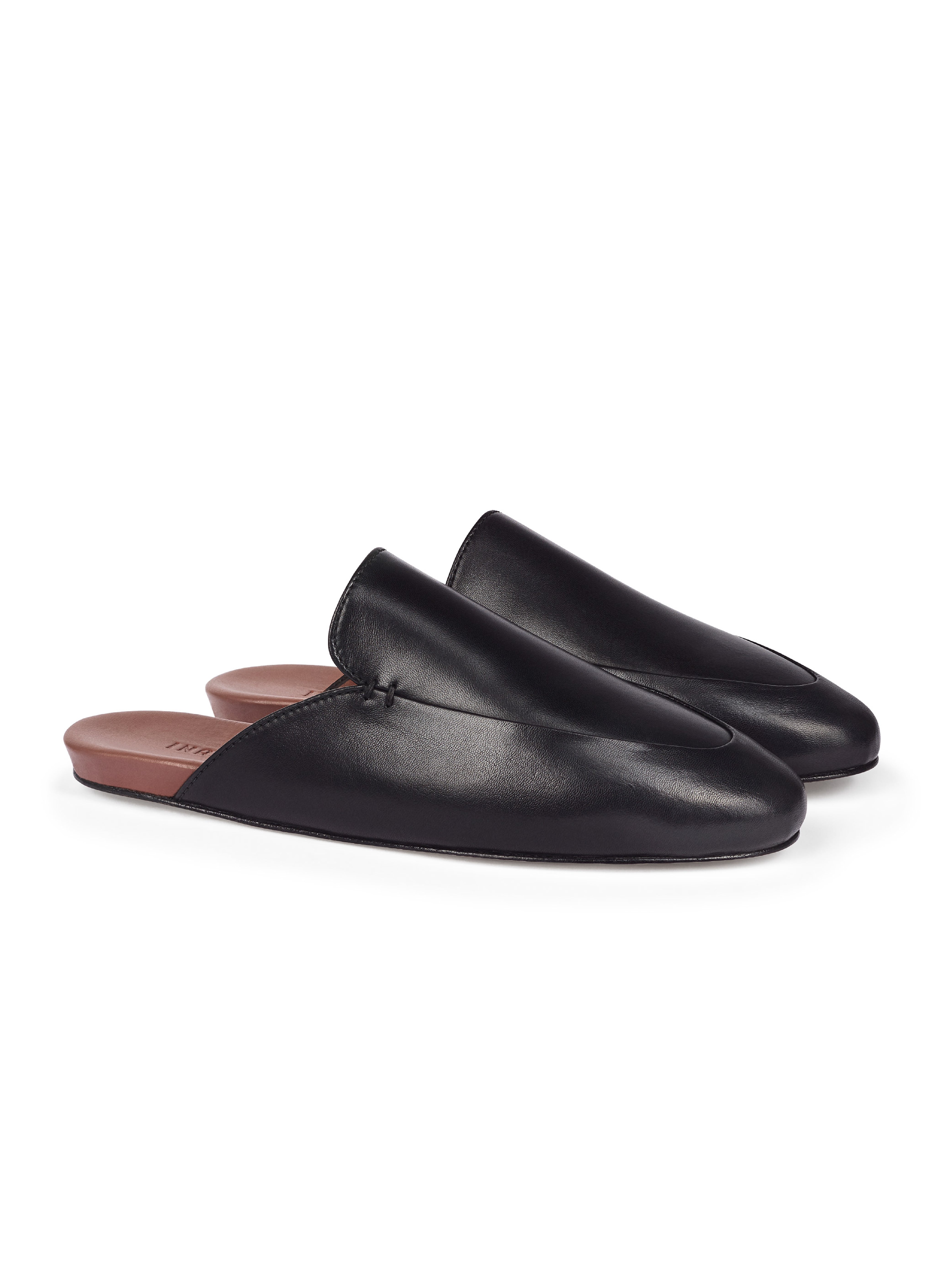 Women's pair of black leather slip-in loafers on a white background.